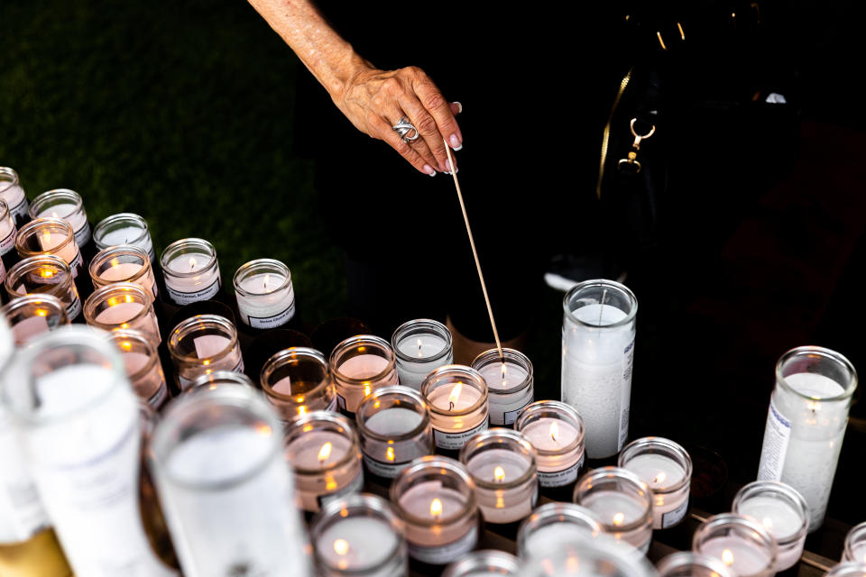 A parishioner lights a votive candle outside the Shrine Church of Our Lady of Mount Carmel, Saturday, July 16, 2022, in the Brooklyn borough of New York. (AP Photo/Julia Nikhinson)