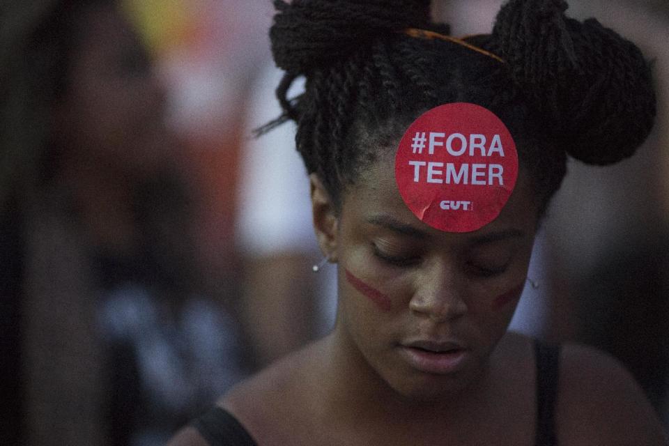 A demonstrator wears a sticker on her forehead that reads in Portuguese "Get out Temer," referring to Brazil's President Michel Temer, during a demonstration against federal government proposed reforms in Rio de Janeiro, Brazil, Wednesday, March 15, 2017. People protested across the country against proposed changes to work rules and pensions. (AP Photo/Leo Correa)