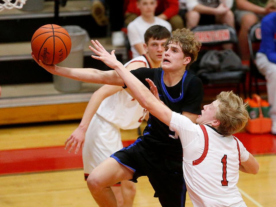 Mapleton High School's Kyle Sloter (5) drives in for a shto against Crestview High School's Tyson Ringler (1) during high school boys basketball action at Crestview High School Thursday, Feb. 9, 2023. TOM E. PUSKAR/ASHLAND TIMES-GAZETTE