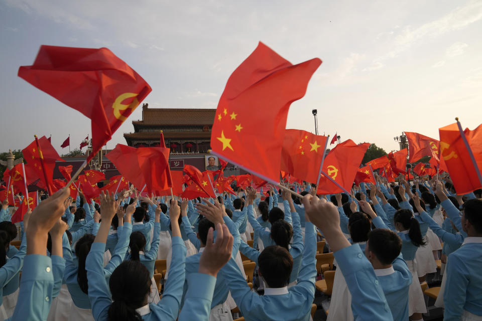 Chinese flags are waved during a rehearsal for a ceremony to mark the 100th anniversary of the founding of the ruling Chinese Communist Party at Tiananmen Gate in Beijing Thursday, July 1, 2021. (AP Photo/Ng Han Guan)