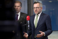 German Minister of State for European Affairs Michael Roth, right, speaks with the media as he arrives for a General Affairs Council meeting at the Europa building in Brussels, Tuesday, Dec. 11, 2018. Top European Union officials ruled out Tuesday any renegotiation of the divorce agreement with Britain as Prime Minister Theresa May launched her fight to save her Brexit deal by lobbying leaders in Europe's capitals. (AP Photo/Virginia Mayo)