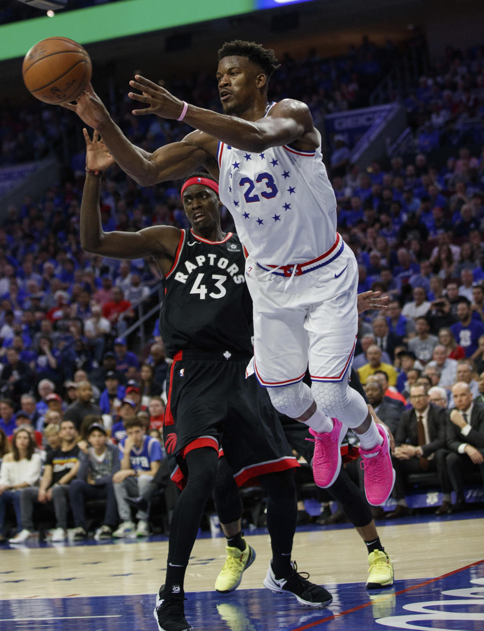 Philadelphia 76ers' Jimmy Butler, right, passes the ball as Toronto Raptors' Pascal Siakam, left, watches during the second half of Game 3 of a second-round NBA basketball playoff series Thursday, May 2, 2019, in Philadelphia. The 76ers won 116-95. (AP Photo/Chris Szagola)