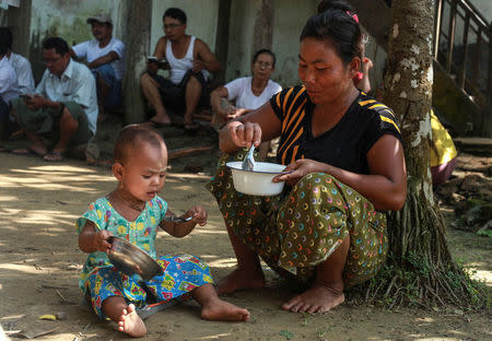 An ethnic Rakhine woman who fled from recent violence in Maungdaw feeds her daughter at a monastery used as a temporary internally displaced persons (IDP) camp in Sittwe, Myanmar October 15, 2016. Picture taken October 15, 2016. REUTERS/Wa Lone