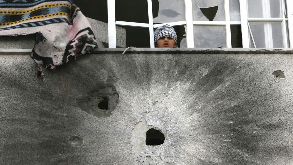 A Palestinian boy looks from the window, just above the pockmarked wall, following overnight clashes between Fatah and Hamas in Gaza in May 2007. - Mohammed Abed/AFP/Getty Images/File