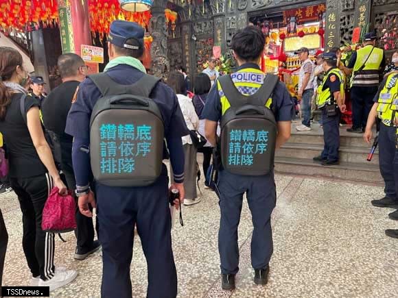 大甲媽祖駐駕員林福寧宮，員林分局特別設計由員警背LED包顯示鑽轎底依序排隊。（記者方一成攝）