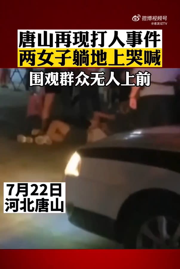  影片顯示，22日晚間，唐山街頭有兩名女子躺在地上哭喊，圍觀民眾議論紛紛，無人上前勸阻。 （圖／截自微博） 