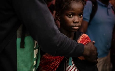 A young girl stares into the distance as people from the town of Buzi unload at Beira Port after being rescued yesterday - Credit: &nbsp;Andrew Renneisen/&nbsp;Getty