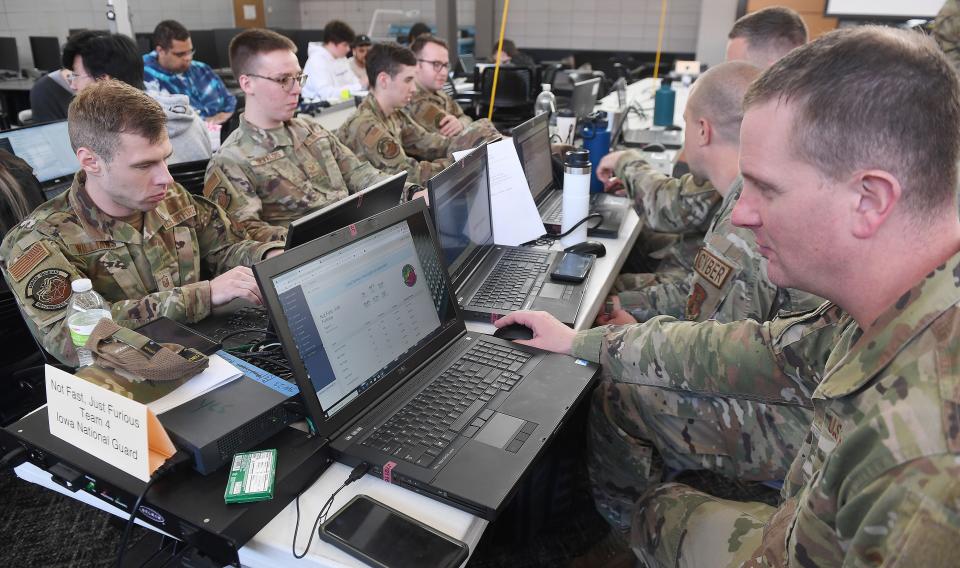 Members of the Iowa Air National Guard work to secure a network from cyberattacks during a cybersecurity competition at Iowa State University's Coover Hall Wednesday, May 18, 2022, in Ames, Iowa.