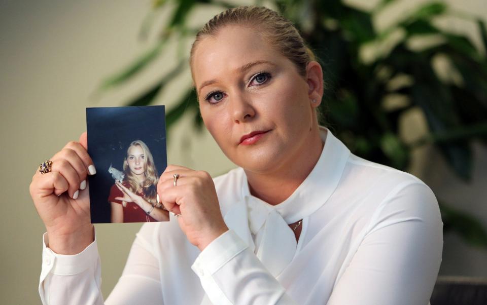 Virginia Roberts Giuffre with a photo of herself at age 16, when she says Jeffrey Epstein began abusing her sexually - Emily Michot/Miami Herald/Tribune News Service via Getty Images