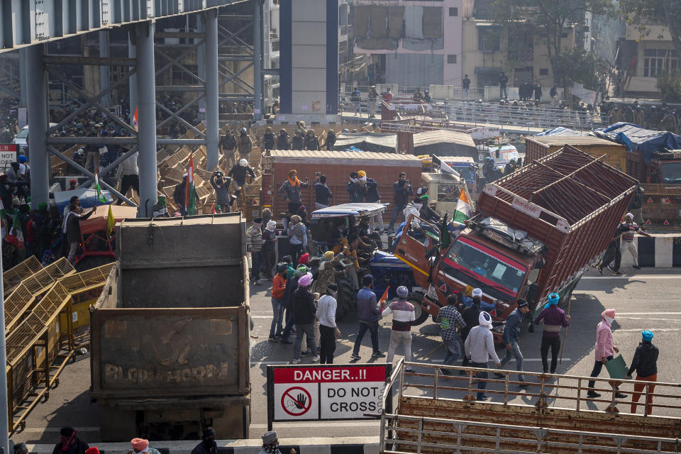 Protesting farmers drive a tractor into a truck that was being used as a barricade by police, as they make their way while marching to the capital, breaking through police lines, during India's Republic Day celebrations in New Delhi, January 26, 2021. / Credit: Altaf Qadri/AP