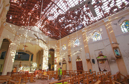 A crime scene official inspects the site of a bomb blast inside a church in Negombo, Sri Lanka April 21, 2019. REUTERS/Stringer