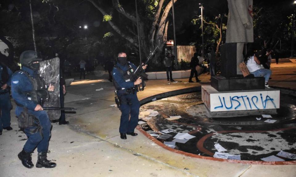 Police officers disperse a protest against the murder of a woman at a square near the city hall in Cancún on Monday.