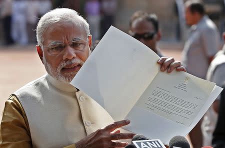 Narendra Modi shows to the media a letter which he received from India's President Pranab Mukherjee after meeting him at the Presidential Palace in New Delhi May 20, 2014. REUTERS/Adnan Abidi