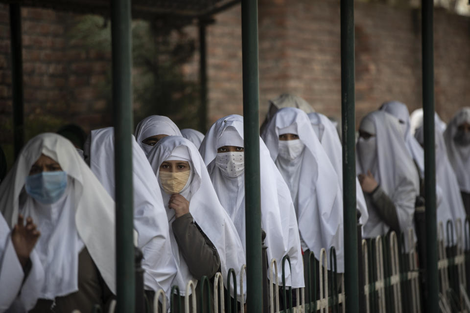 Kashmiri students wearing face masks arrive to attend a school in Srinagar, Indian controlled Kashmir, Monday, March 15, 2021. Schools reopened for the lower grades Monday in Indian-controlled Kashmir, eleven months after being closed due to the coronavirus pandemic. (AP Photo/Mukhtar Khan)