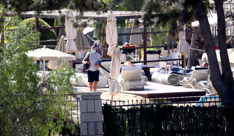 FOTO DE ARCHIVO: Un huésped usa una mascarilla protectora mientras camina dentro del hotel H10 Costa Adeje Palace, el cual está clausurado después de que el coronavirus de la novela haya sido confirmado en Adeje, Tenerife