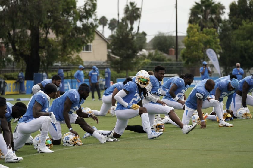 Los Angeles Chargers players stretch during an NFL football camp practice.