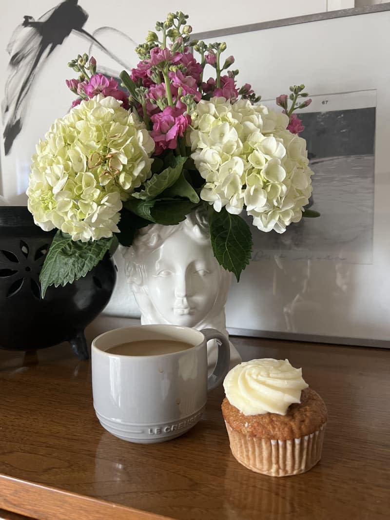 White relief head vase with hydrangeas and coffee and cupcake