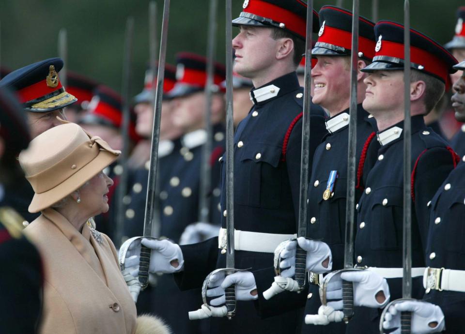 Prince Harry smiling broadly as his grandmother the Queen reviews him and other officers during The Sovereign’s Parade at Sandhurst in 2006 (James Vellacott/PA) (PA Wire)