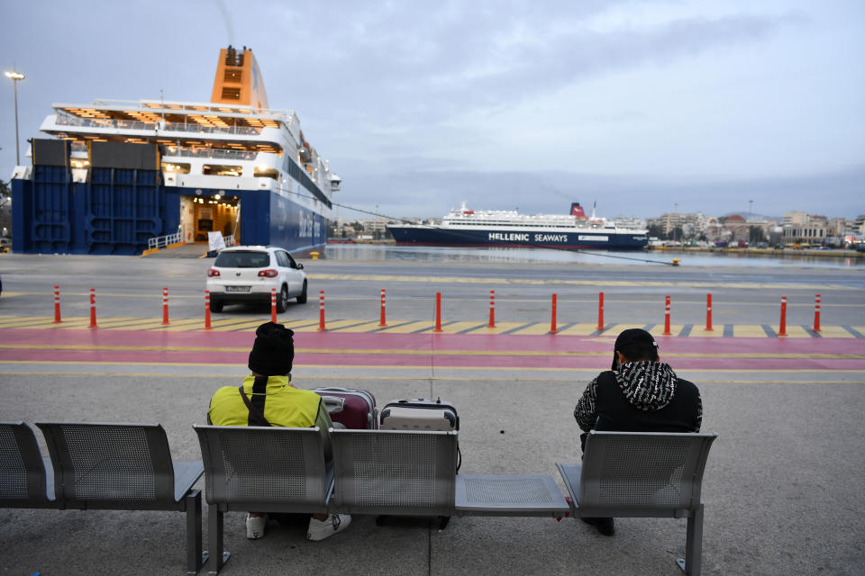 Two men sit on a bench as the ferries are docked at the port of Piraeus near Athens, during a strike on Wednesday, Feb. 28, 2024. A nationwide 24-hour strike by public and some private sector workers is expected to disrupt public transport and leave ferries tied up in port. (AP Photo/Michael Varaklas)