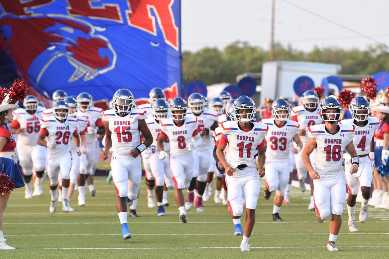 The Cooper football team runs onto the field before last season's Southtown Showdown against Wylie at Sandifer Stadium. The Cougars won 30-24. Cooper opens the season against Keller at 7 p.m. Thursday at Shotwell Stadium.