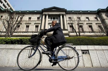 A man rides a bicycle past the Bank of Japan (BOJ) building in Tokyo March 18, 2009. REUTERS/Yuriko Nakao/File Photo