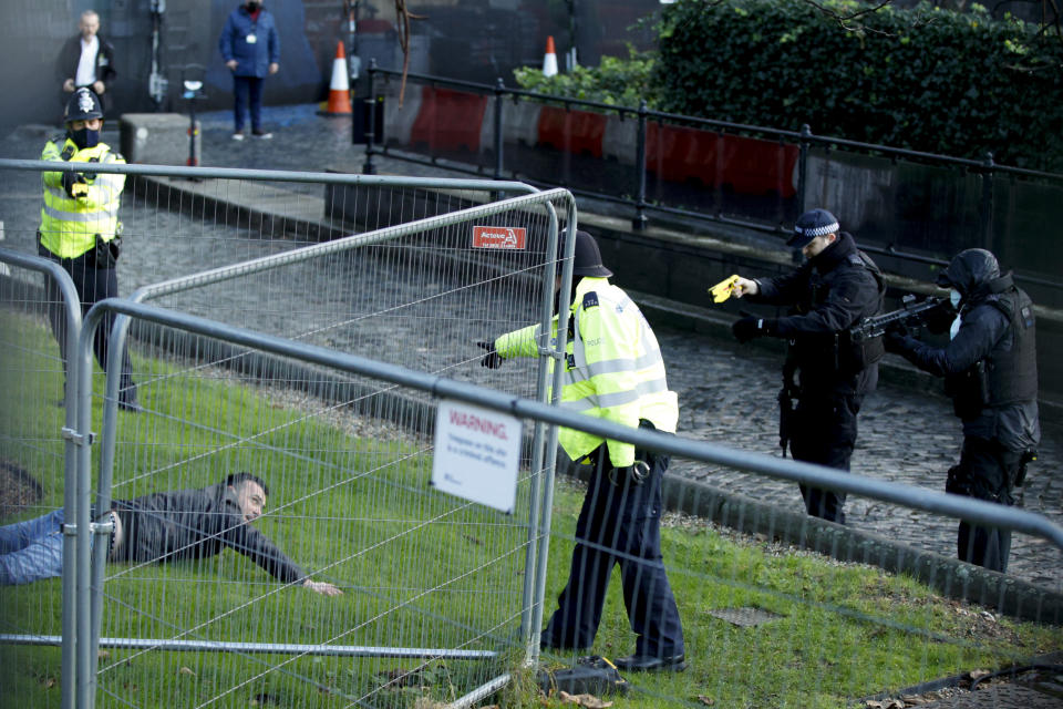 Police officers detain a man after he entered the grounds of the Houses of Parliament in London, Wednesday, Dec. 1, 2021. (AP Photo/David Cliff)