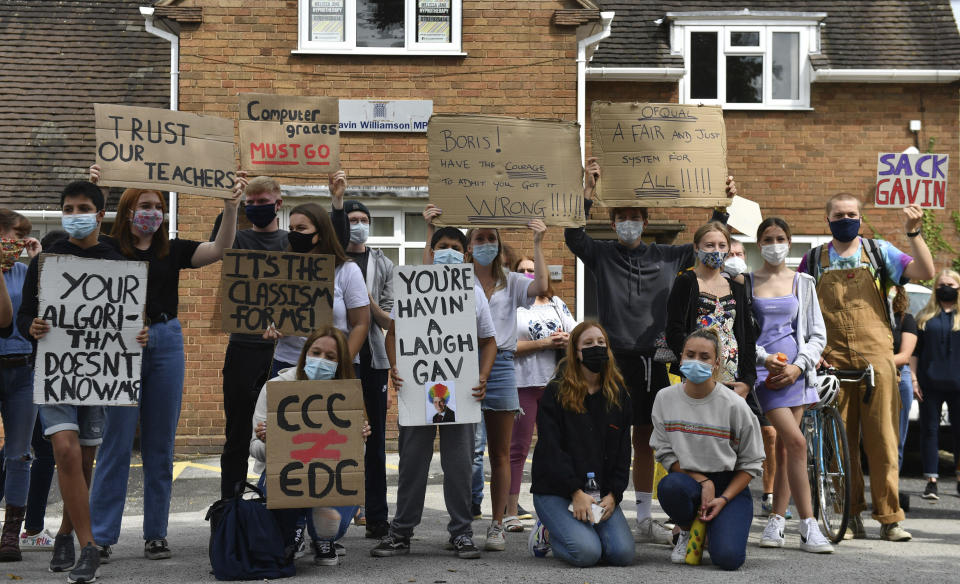 Students mount a protest outside the constituency office of their local lawmaker, Education Secretary Gavin Williamson, in South Staffordshire, England, Monday Aug. 17, 2020.  Students are protesting over the government's handling of A-level results, using an algorithm to work out marks, with many students receiving lower than expected grades after their exams were cancelled because of the coronavirus restrictions. (Jacob King/PA via AP)