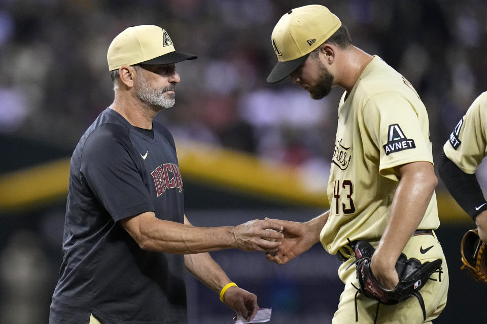 Arizona Diamondbacks manager Torey Lovullo, left, takes the ball from starting pitcher Slade Cecconi (43) during the fourth inning of a baseball game against the Baltimore Orioles, Saturday, Sept. 2, 2023, in Phoenix. (AP Photo/Ross D. Franklin)