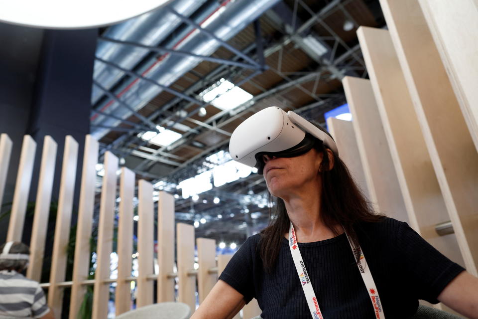 An attendee wearing a virtual reality (VR) headset tries out a VR application on the Meta Platforms Inc. booth at the Viva Technology conference dedicated to innovation and startups at Porte de Versailles exhibition center in Paris, France June 16, 2022. REUTERS/Benoit Tessier