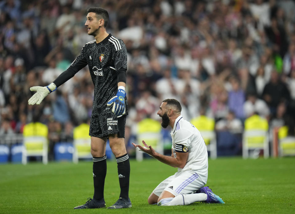 Karim Benzema (derecha) del Real Madrid y el arquero Sergio Herrera del Osasuna durante el empate 1-1 en la Liga española, el domingo 2 de octubre de 2022 (AP Foto/Manu Fernández)