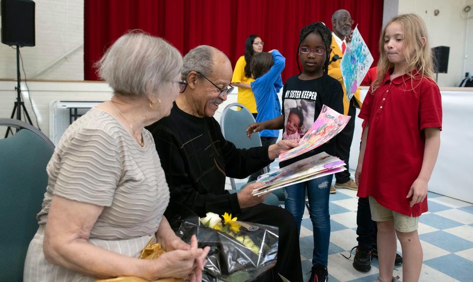 Students from Dixon School of Arts and Sciences present Sculptor and former Astronaut Ed Dwight and his wife Barbara with gifts during a visit to the school on Friday, March 24, 2023. 