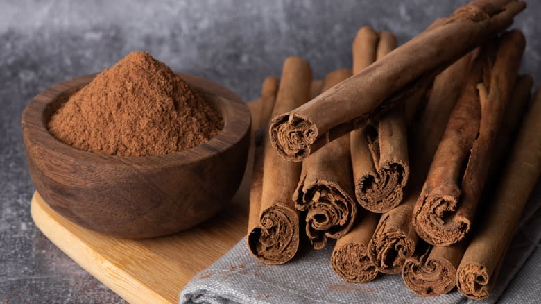 Cinnamon sticks and ground on wood