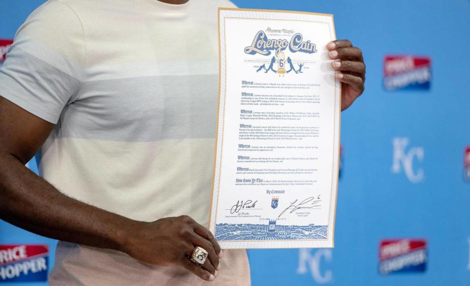 Former Kansas City Royals center fielder Lorenzo Cain holds up a one-day ceremonial contract he signed during a press conference to retire with the Royals at Kauffman Stadium on Saturday, May 6, 2023, in Kansas City.