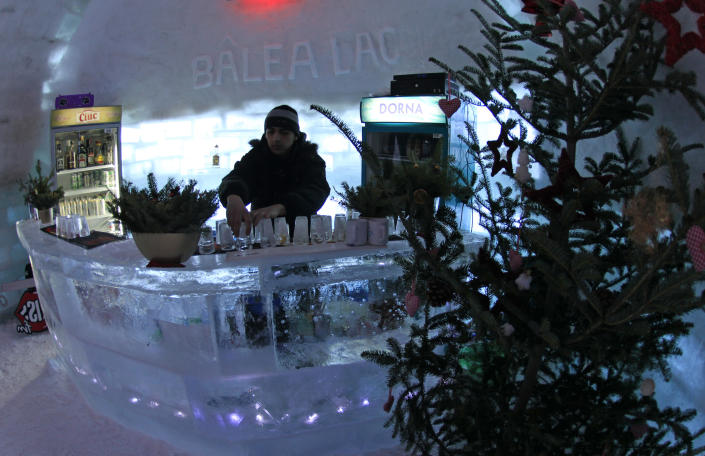 A bartender arranges ice glasses inside the Balea Lac Hotel of Ice in the Fagaras mountains, 300km (184 miles) northwest of Bucharest December 28, 2011. Entirely made of ice, the hotel offers accommodation in 10 double rooms with king size beds, where the temperature is between -2 and 2 degrees Celsius, at a price of 35 Euro ($45.73) per person. REUTERS/Radu Sigheti (ROMANIA - Tags: SOCIETY TRAVEL)