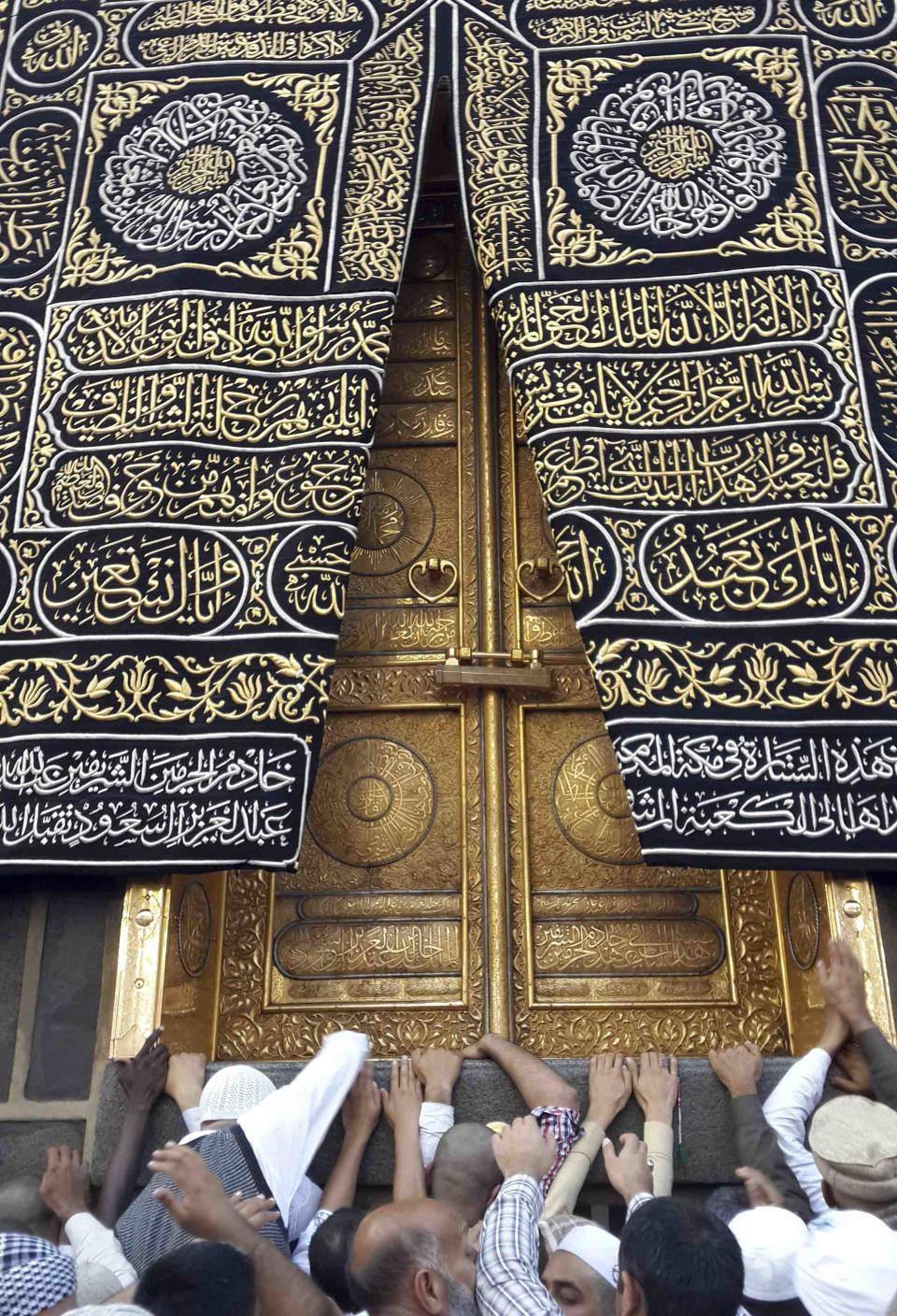 Muslims touch and pray at the door of the Kaaba, during their Umrah Mawlid al-Nabawi pilgrimage, at the Grand Mosque in the holy city of Mecca