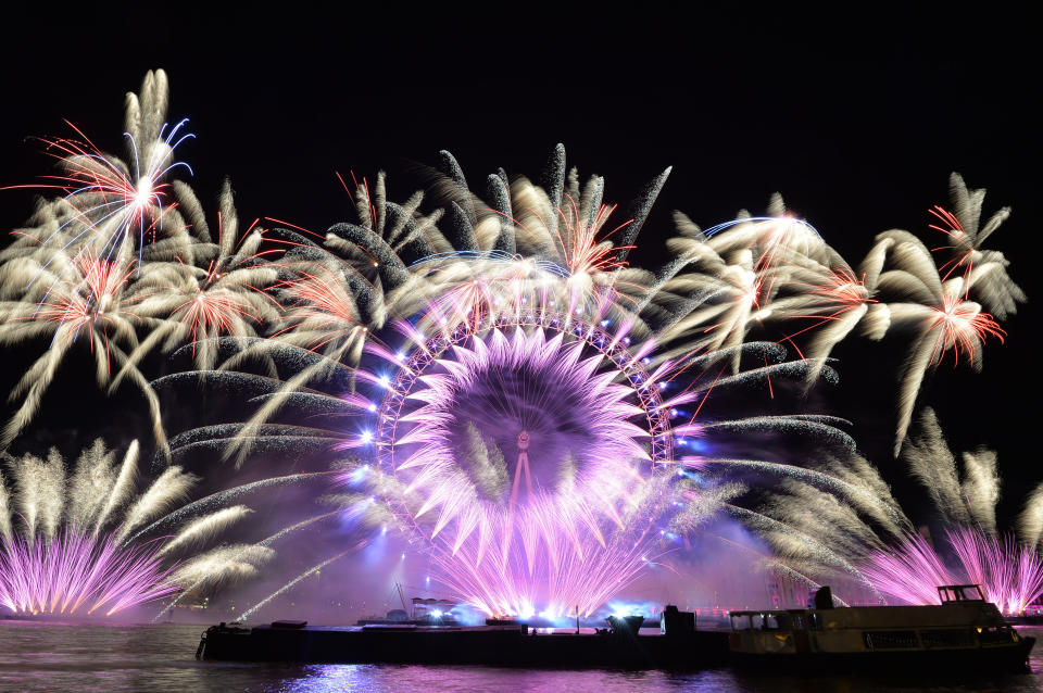 <p>Fireworks light up the sky over the London Eye in central London during the New Year celebrations. (Photo: John Stillwell/PA Images via Getty Images) </p>