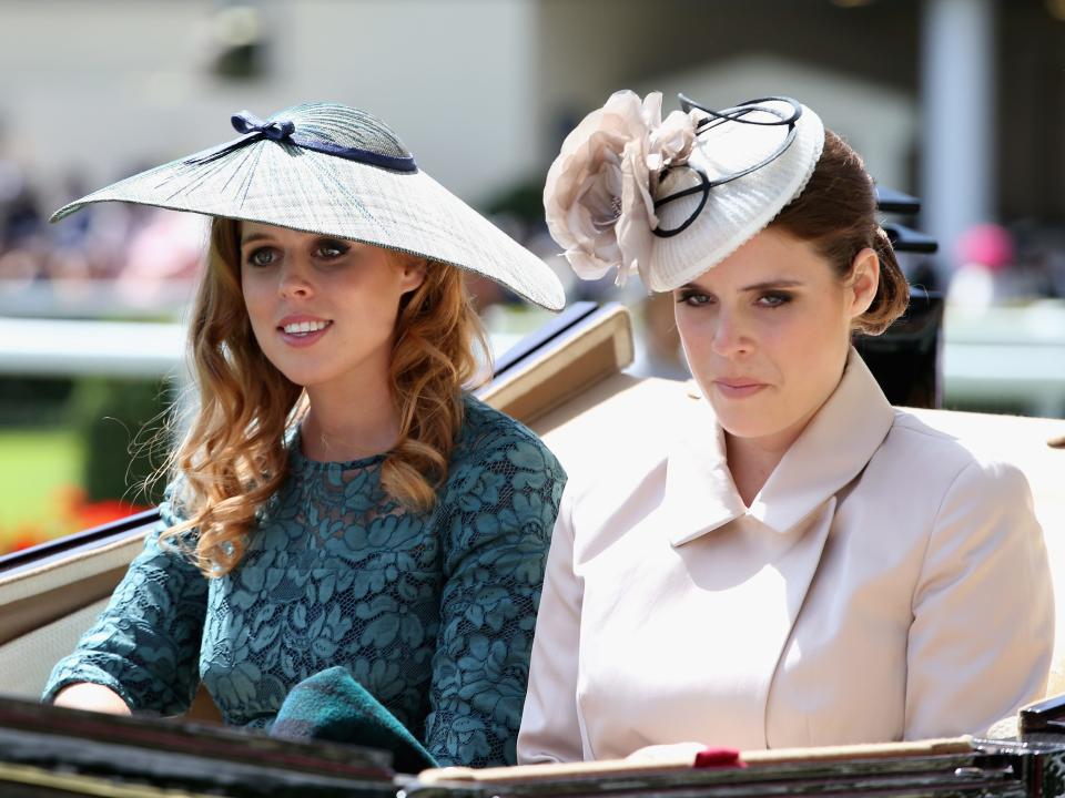 Princesses Beatrice and Eugenie ride in a horse-drawn carriage.