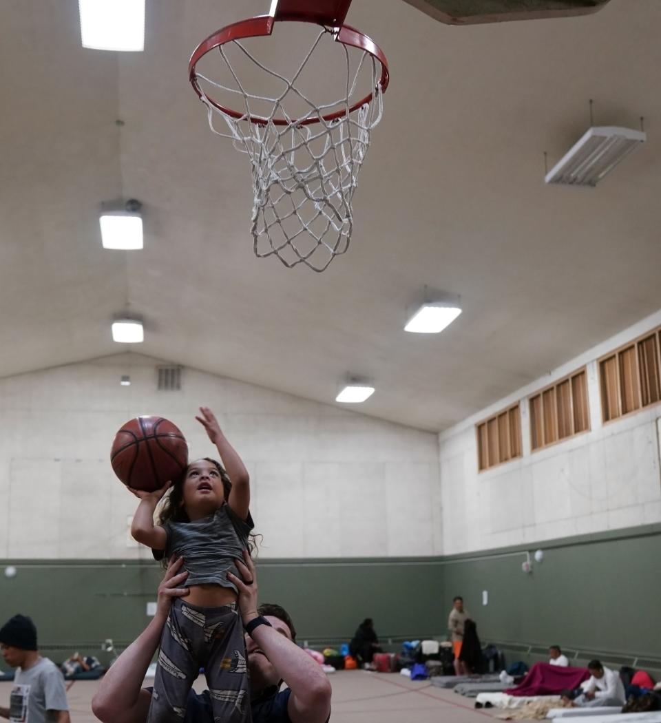 Denver Friends Church pastor Keith Reeser plays basketball with Will Daniel Torres y Wisler, 4, in the church's gym, which has been converted to a shelter for migrants, most of them from Venezuela.