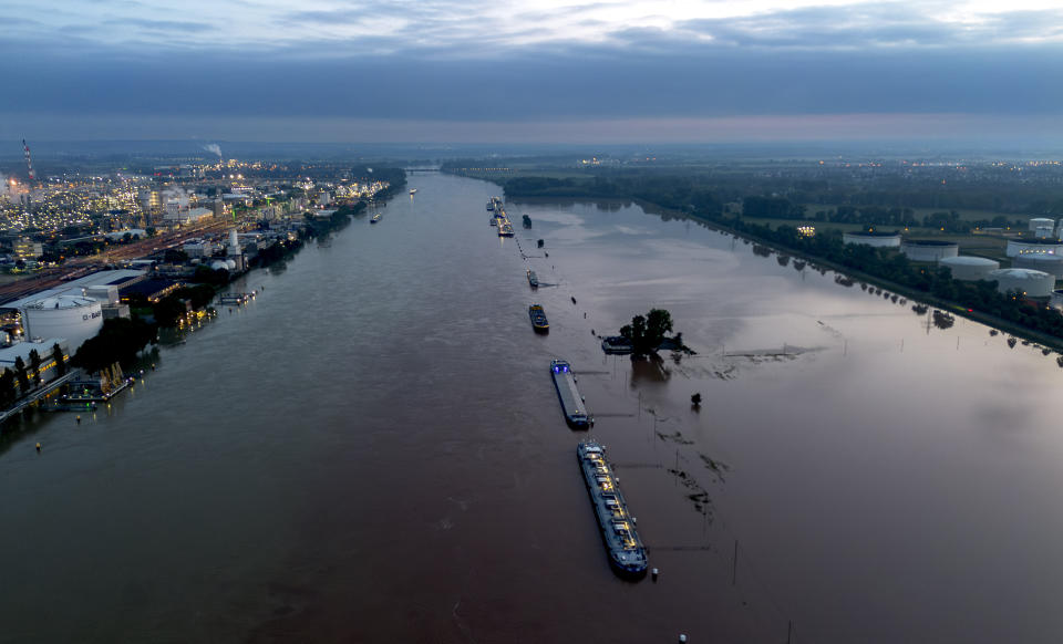 Cargo ships park at the bank of the river Rhine near the BASF chemical plant in Ludwigshafen, Germany, Tuesday, June 4, 2024. The Rhine left its banks after heavy rain falls in southern Germany during the last days. (AP Photo/Michael Probst)