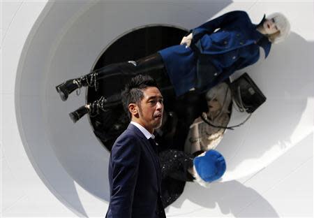 A man walks past a display window of a luxuary shop at Ginza shopping district in Tokyo October 31, 2013. REUTERS/Yuya Shino