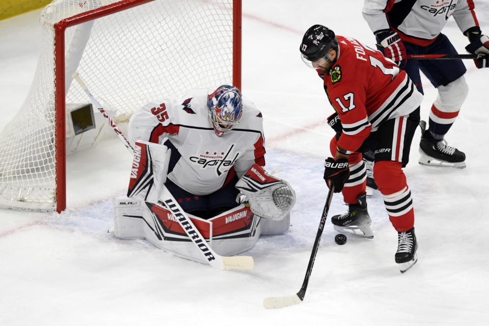 Washington Capitals goalie Darcy Kuemper (35) makes a save against Chicago Blackhawks' Nick Foligno (17) during the first period of an NHL hockey game Sunday, Dec. 10, 2023, in Chicago. (AP Photo/Paul Beaty)