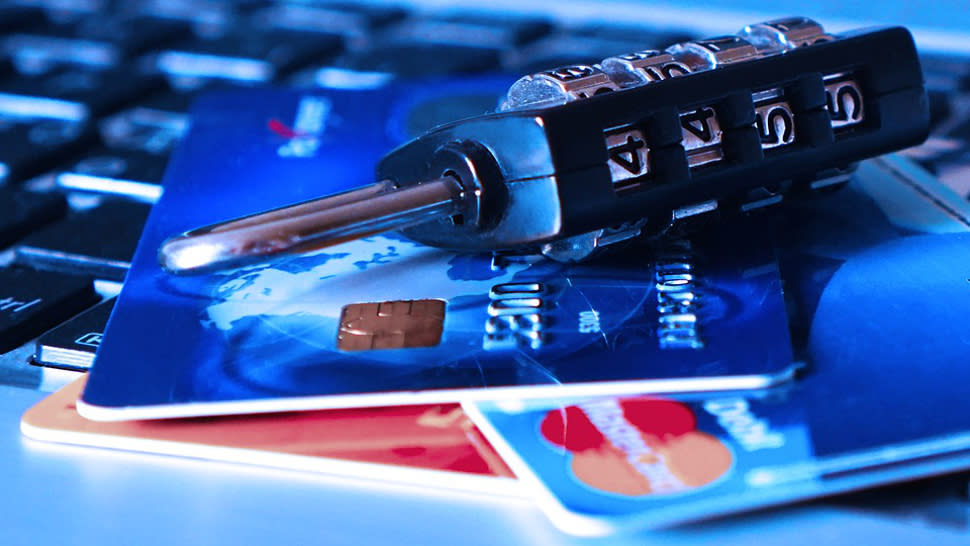  Credit cards and a padlock on top of a computer keyboard 