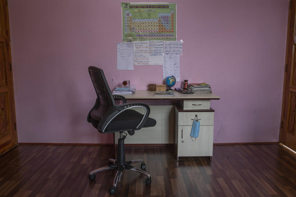 A face mask hangs on a study table of a Kashmiri student in Srinagar, Indian controlled Kashmir, Friday, July 18, 2020. Experts say lack of formal schooling during the lockdown could have a serious psychological and emotional impact on the children. With no opportunity to be with friends, many homebound students are struggling to reimagine the school experience as parents take over the role of teachers. (AP Photo/ Dar Yasin)