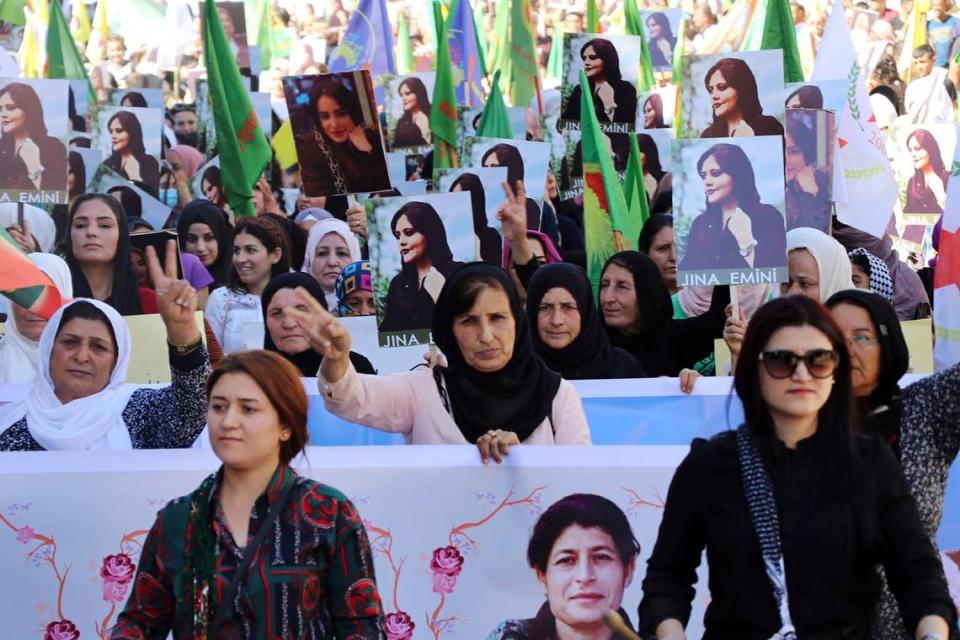 In this photo provided by Kurdish-run Hawar News Agency, Kurdish women hold portraits of Iranian Mahsa Amini, during a protest condemning her death in Iran, in the city of Qamishli, northern Syria, Monday, Sept. 26, 2022. Protests have erupted across Iran in recent days after Amini, a 22-year-old woman, died while being held by the Iranian morality police for violating the country’s strictly enforced Islamic dress code. (Hawar News Agency via AP via AP)