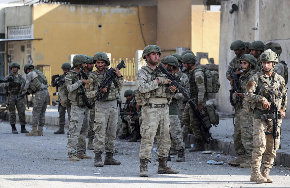 Turkish soldiers secure in Syrian town of Ras al Ayn, northeastern Syria, Wednesday, Oct. 23, 2019. Turkish media reports say Turkish troops and their allied Syrian opposition forces are securing a town in northeast Syria after Syrian Kurdish fighters pulled out of the area.(Ugur Can/DHA via AP)