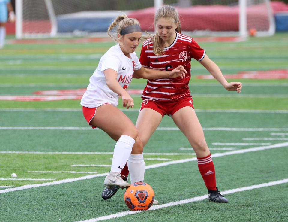 Monroe's Gabby Willis and Libby Ewing of Bedford battle for the ball on Thursday, April 18, 2024. Monroe won 7-1.