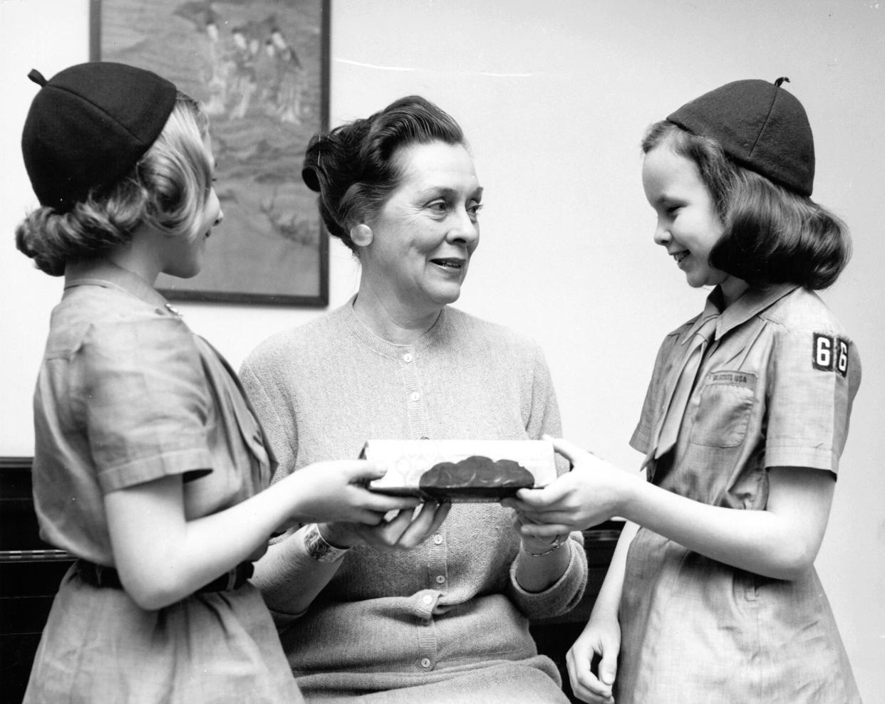 Two Girl Scout Brownies Present a Box of Cookies to an Older Woman, Vintage Black & White, 1963