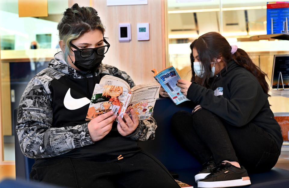 Framingham sixth-graders Natalia Figueroa, left, and Danna Rivera read manga books in the Fuller Middle School library, Jan. 21, 2022. The city's school libraries have seen an increase in circulation during the pandemic.