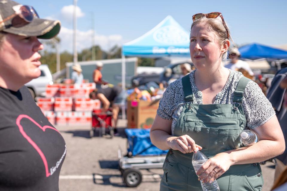 Oct 5, 2024; Asheville, NC, USA; MANNA employee Jenn Lutz talks Liz Hipps to as MANNA FoodBank provide resources to residents at the WNC Farmers Market during the aftermath of flooding caused by the remnants of Hurricane Helene. Mandatory Credit: Nathan Fish-USA TODAY