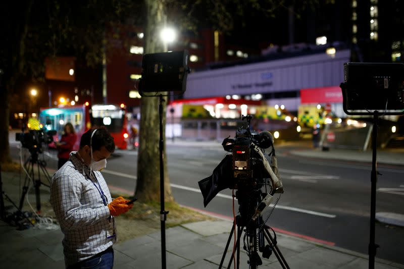 A journalist wearing a face mask is seen outside of the St Thomas' Hospital after British Prime Minister Boris Johnson was moved to intensive care